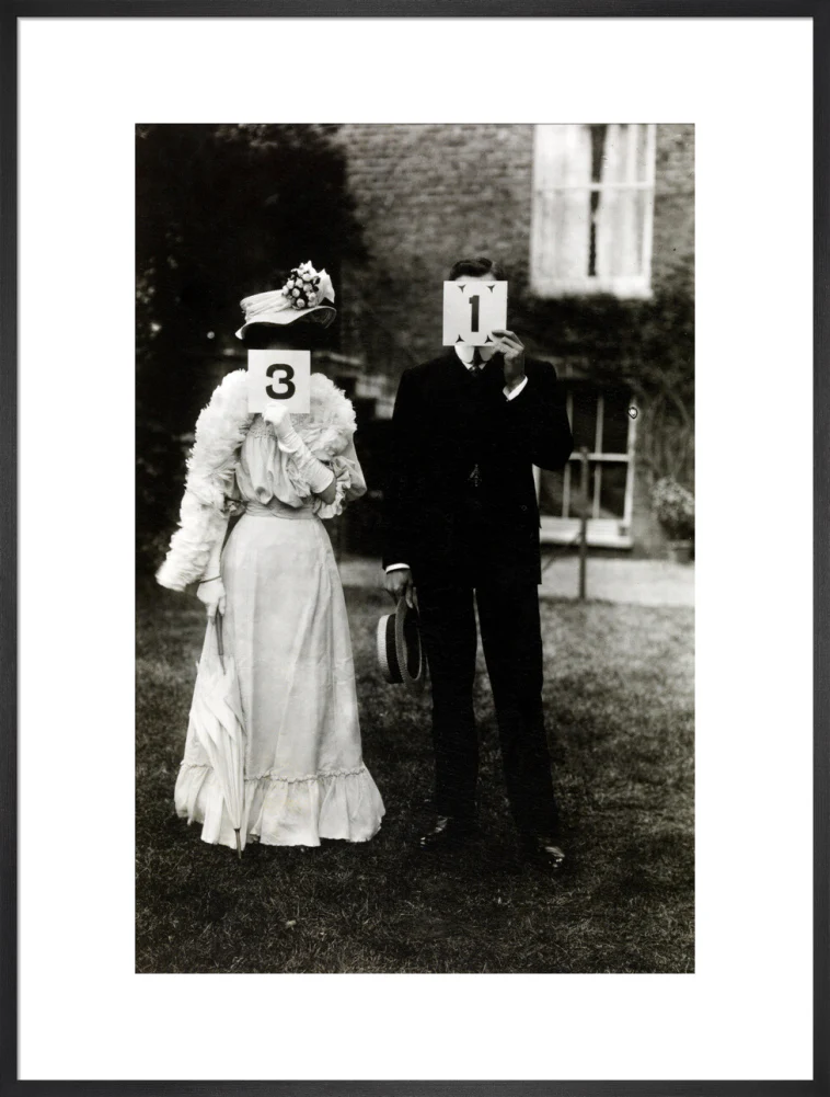 A couple, each holding up a number in front of their face circa 1905 - Image 56