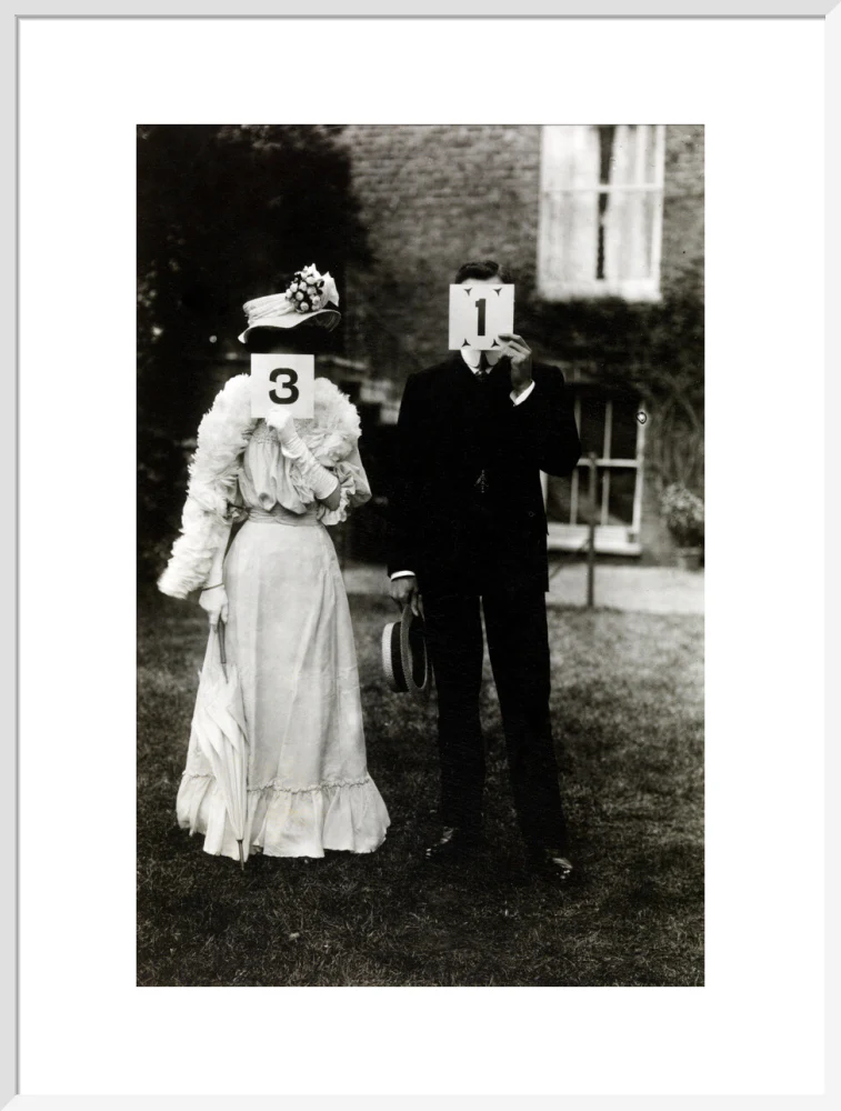 A couple, each holding up a number in front of their face circa 1905 - Image 57